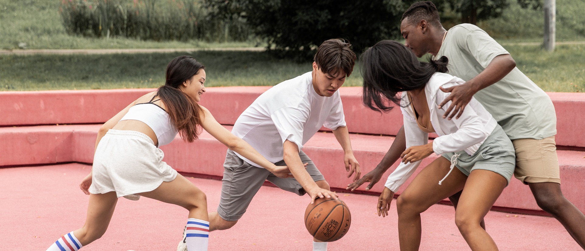 Junge Menschen spielen zusammen Basketball.