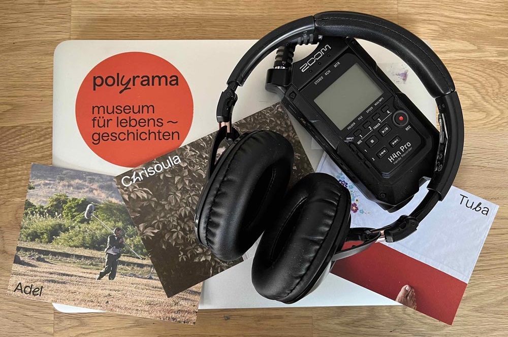 Zu sehen sind Kopfhörer, eine Karte des polyrama-museums sowie ein Tongerät.