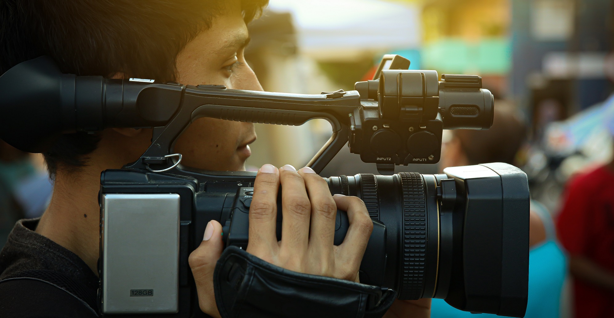 Ein Jugendlicher sieht durch eine Filmkamera.