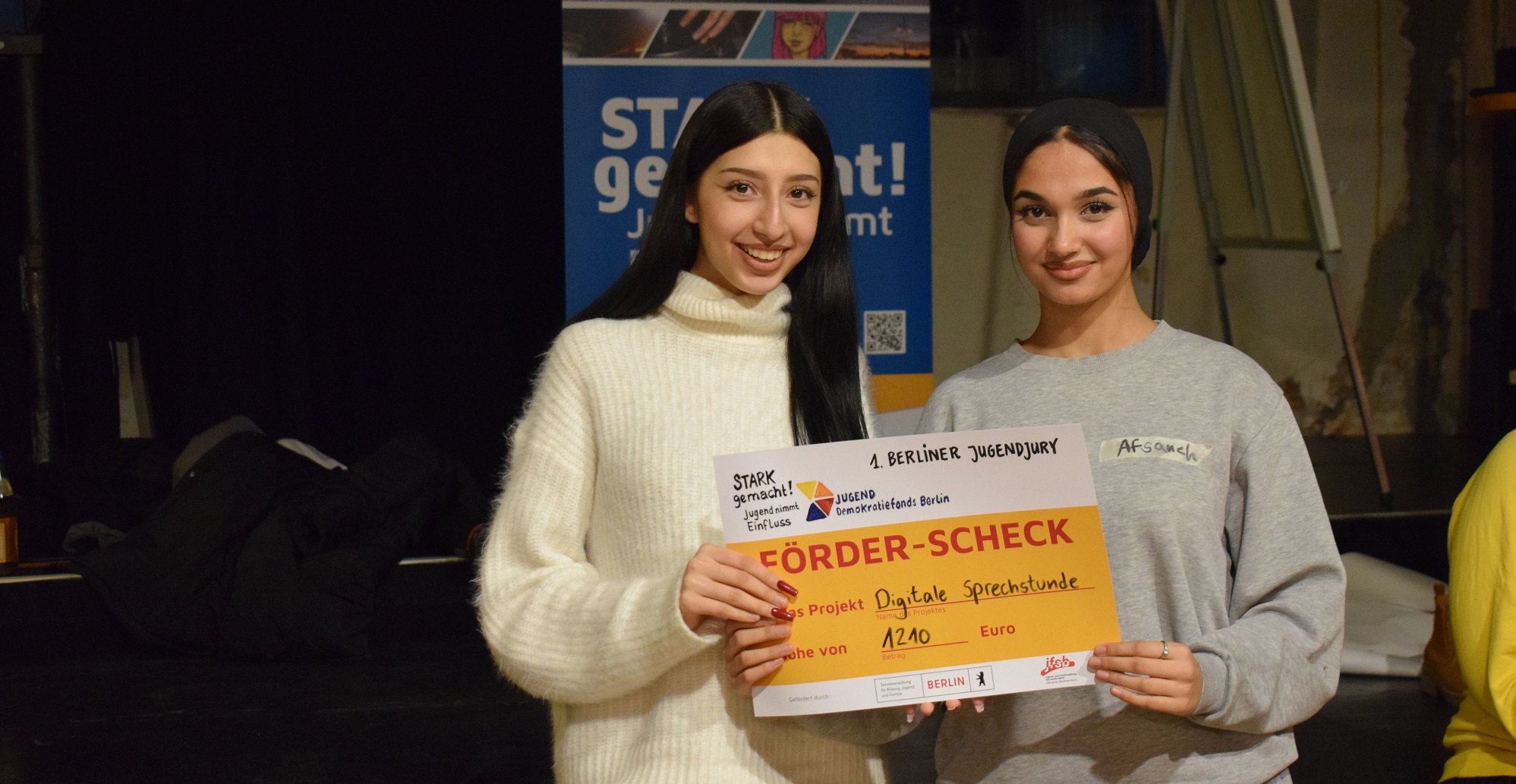 Zwei junge Menschen halten den Check für das Projekt "Digitale Sprechstunde" in den Händen